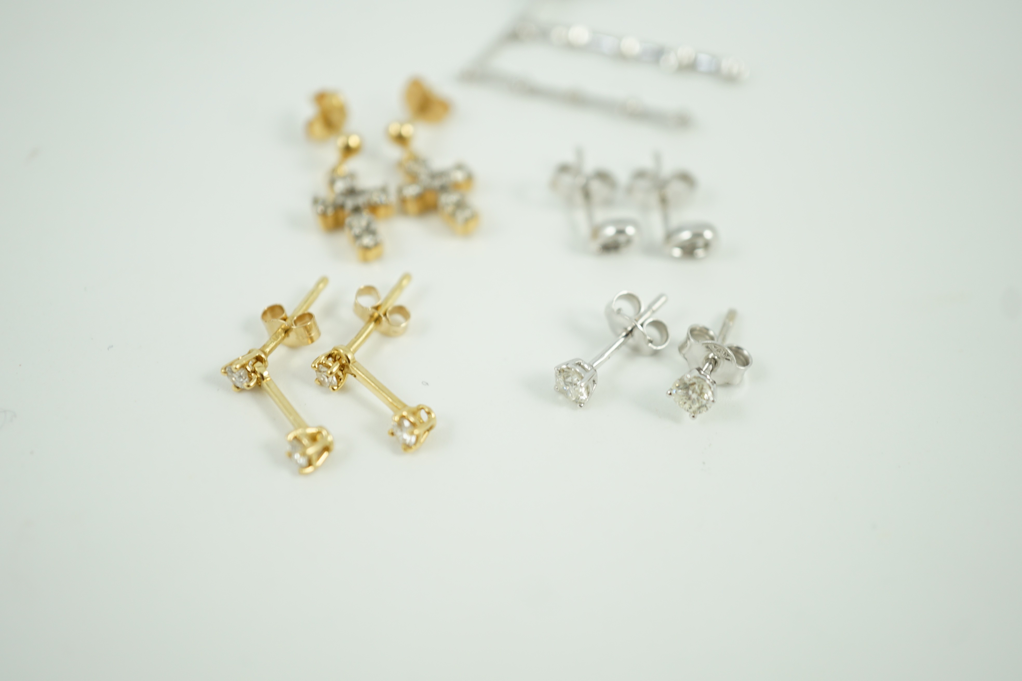 Three pairs of 18ct white gold and diamond set ear rings, including solitaire ear studs and two other pairs of 18ct gold and diamond set ear studs including cross, largest 24mm, gross weight 6.4 grams.